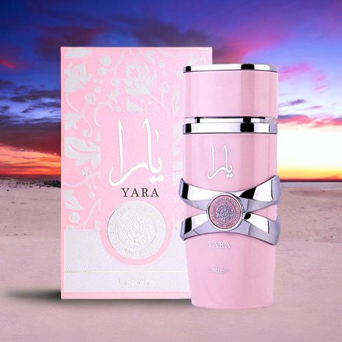 Perfume árabe Yara Lattafa feminino com frasco rosa pastel e detalhes prateados ao lado de sua caixa rosa com arabescos florais sobre fundo branco.