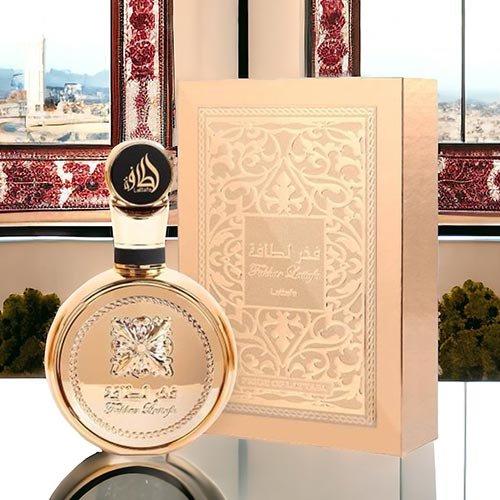 Perfume árabe Fakhar Lattafa Gold com frasco arredondado dourado espelhado e caixa de luxo texturizada em tom ouro sobre superfície reflexiva.